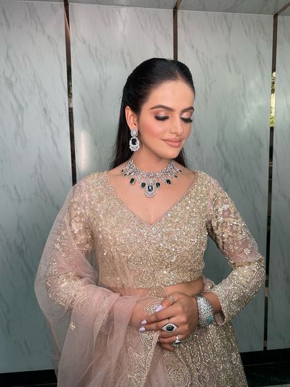 This engagement look is simply stunning. The bride is wearing a heavy AD and emerald necklace that perfectly complements her shimmery lehenga.