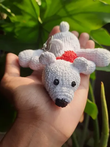A front-facing view of the polar bear keychain with its scarf. The simple, sweet expression makes it an adorable companion.