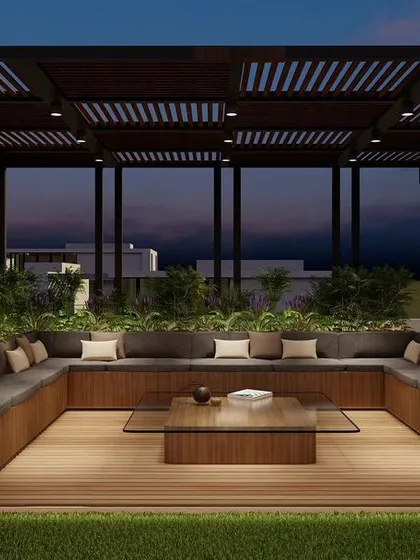 This design for a Punjabi Bagh terrace features a large, U-shaped seating area under a slatted pergola. The wooden deck and built-in planters create a warm and inviting space for large gatherings.