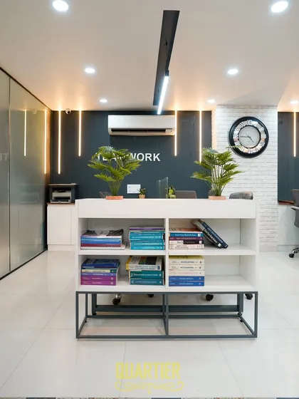 A perspective from the entrance, showing how the different elements come together. The design uses linear lighting and vertical light strips to create a sense of height and modernity, guiding the eye through the space towards the main work areas.