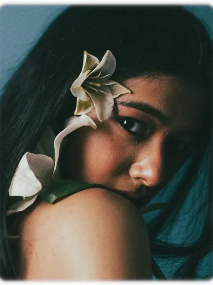 Another portrait from the floral series, this time with a white lily placed on the shoulder. The shadow of the flower on the model's skin adds an interesting textural element, and her glance over the shoulder is both shy and alluring.