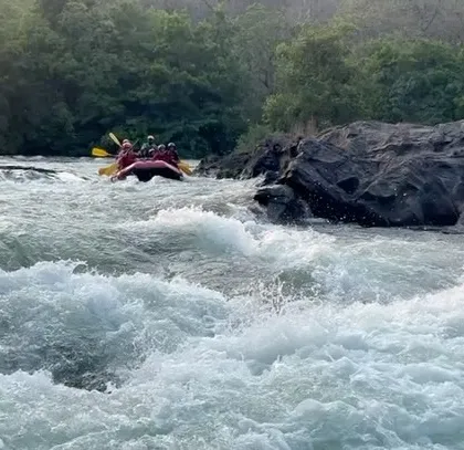 A raft approaches a rocky passage, showing the technical challenges and natural beauty of the Dandeli river course.
