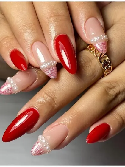 A bright red almond-shaped set with textured, pearl-encrusted accent nails. This design combines classic color with modern, tactile art.