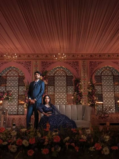 A grand, wide-angle shot of the reception stage. This photo showcases the beautiful decor and the couple as the centerpiece of the celebration.