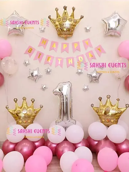 A simple yet elegant princess-themed first birthday setup with pink, white, and silver balloons and crown foils.