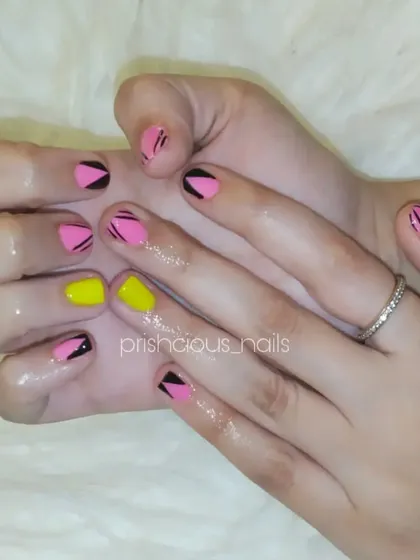 A cute and geometric design with pink, yellow, and black on natural nails.