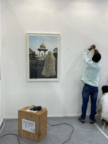 Our team carefully installing a photograph by Surekha for Art Mumbai.