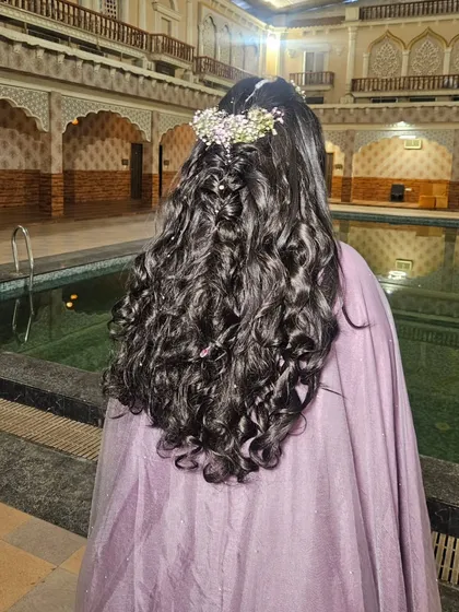 A beautiful shot of the open hairstyle with soft curls and a floral crown, perfect for a daytime Haldi function.