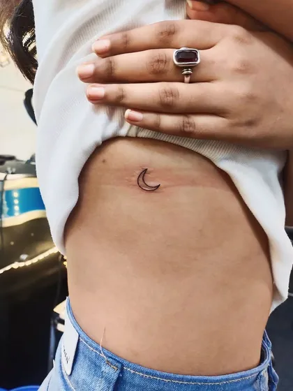 Another take on the crescent moon, this minimalist tattoo is placed on the ribcage for a more personal and hidden piece of art.