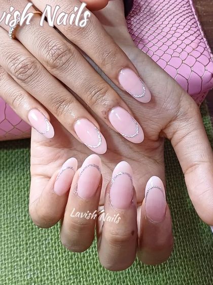 A very delicate and minimalist design with sheer pink nails and a fine, curved silver glitter line.