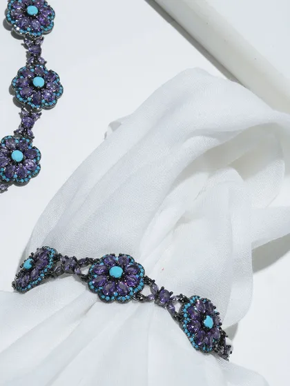 A creative shot of the Amethyst and Turquoise bracelet and necklace, highlighting the intricate floral design of each link.