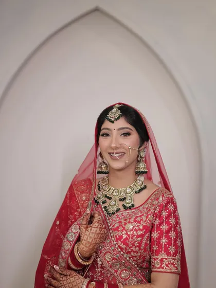This is my bride Kashish, who was an absolute dream to work with. For her wedding day, we chose a classic look with beautifully defined eyes and a soft lip color that complemented her red and green jewellery.