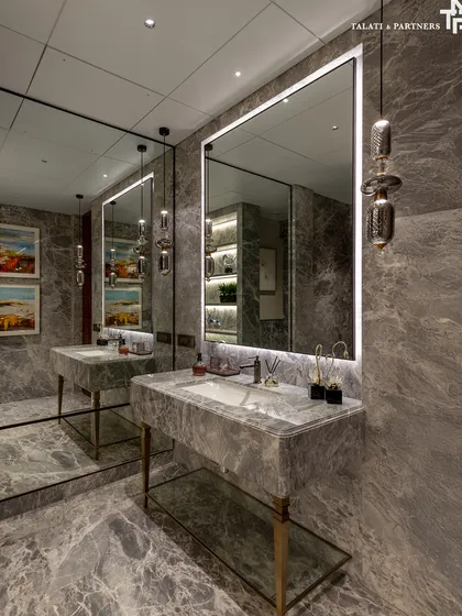 This bathroom in a Shivaji Park residence is an immersive experience in materiality. Clad entirely in a dramatic grey marble, the space features a custom vanity with brass legs and a large mirror, creating a quaint sanctuary of lived-in luxury.