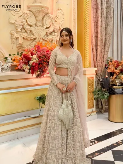 You don’t have to buy a lehenga to feel like it’s made for you. This client looks stunning in a full-length shot of the beige lehenga, complete with a matching potli bag.