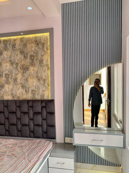 A modern dressing unit with a semi-circular mirror, integrated into a fluted wall panel. The design is both space-saving and stylish.