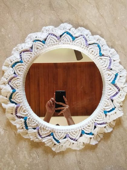 Reflecting artistry with every knot. This handcrafted macrame mirror with pops of blue and purple adds boho chic vibes and intricate texture to any space.