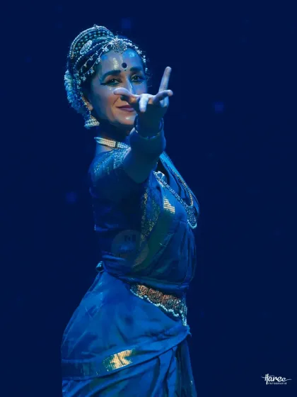 Bathed in blue light, this close-up captures a moment of storytelling. The lighting design is a crucial collaborator in setting the emotional tone of a piece.