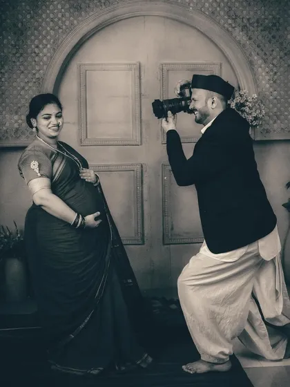 We love to have fun during our sessions. Here, the father-to-be playfully takes on the role of the photographer, adding a touch of lightheartedness to this otherwise formal and artistic vintage shoot.