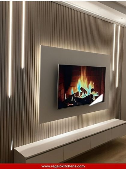 This TV wall uses vertical LED strips embedded in a fluted panel to create a dramatic lighting effect. The simple floating console keeps the look clean and modern.