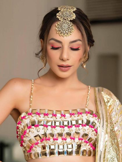 This look features a stunning neon pink winged liner that perfectly matches the details in the blouse. It is a great example of how to create a cohesive, high-impact look.