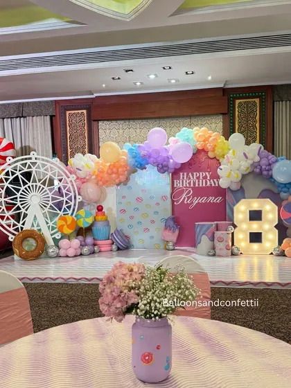 A full stage view of the Candyland theme for Riyana's 8th birthday. The setup includes a custom backdrop, marquee number, and tons of sweet-themed props.