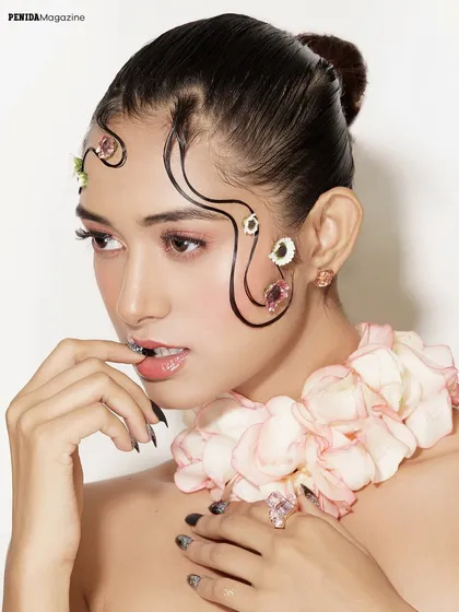 This shot highlights the glossy finish on the lips and the delicate placement of gems and flowers. It's a fantasy look, blending natural elements with polished execution.