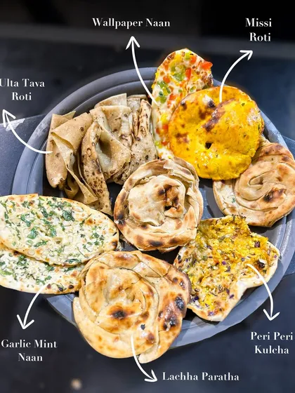 I take pride in perfecting the basics, like this platter of assorted Indian artisanal breads. This display showcases the variety I offer, from Garlic Mint Naan and Lachha Paratha to the unique Wallpaper Naan and spicy Peri Peri Kulcha.