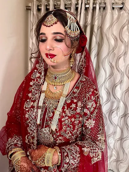 A detailed shot of our best-ever Nikah look. The intricate gold jewelry and the rich red outfit are perfectly complemented by the classic makeup.