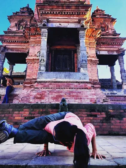 Practicing arm balances like Eka Pada Koundinyasana in front of a temple in Nepal. Yoga allows us to find strength and grace in any setting.