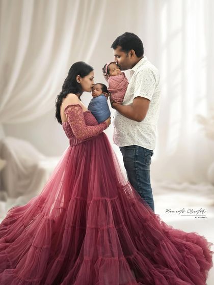 Double the love, double the joy. This portrait of newborn twins with their parents is incredibly special. The mother's flowing gown and the tender way they hold their babies create a magical family photo.