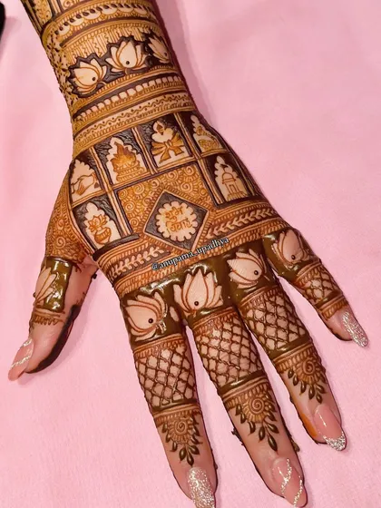 A trendy and intricate bridal backhand design. This pattern features a grid of auspicious symbols, surrounded by delicate lotus flowers on the fingers.