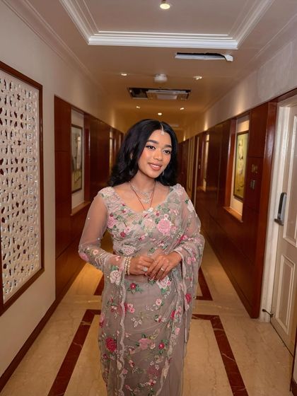 A full-length shot of the "flower girl" bride in her gorgeous floral saree. The soft glam makeup enhances her natural beauty and completes the romantic look.