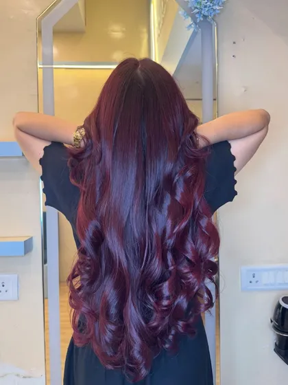 A full view of our wine-red magic. This color is deep, rich, and full of dimension, styled into luxurious curls that catch the light perfectly. This is a true statement color.
