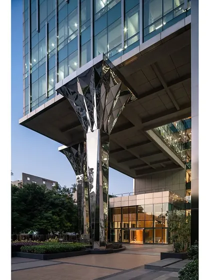 A closer look at the custom-designed faceted stainless steel columns, which reflect the surrounding landscape and add a dynamic, sculptural element to the building's exterior.