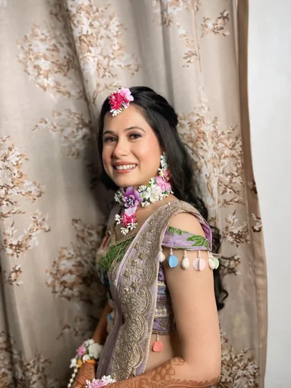 A beautiful Haldi bride adorned with custom floral jewelry. We kept her makeup minimal and fresh to complement the natural theme.