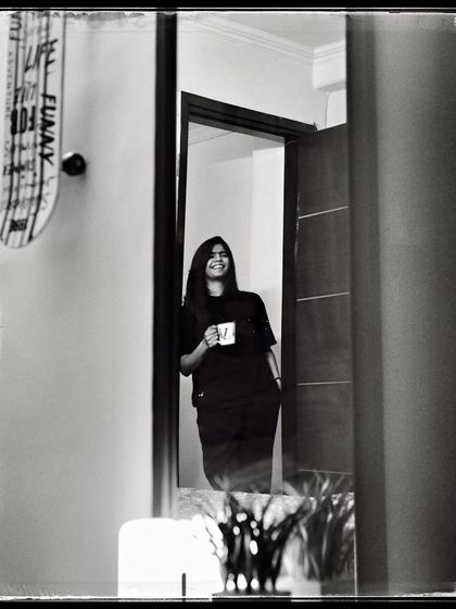 Vasu, enjoying a cup of coffee in her doorway. A simple, everyday moment that feels peaceful and content.