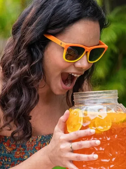 A candid, fun moment captured for a sunglasses campaign. The model's excited expression and the summery, outdoor setting make the product feel connected to joy and good times.