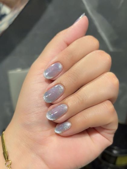 A subtle cat eye effect with a glittery finish on short, natural nails.