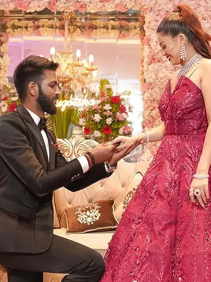 The classic proposal moment, captured with all its heartfelt emotion. The groom on one knee against a stunning wall of pink flowers makes for a perfect engagement photograph that you will treasure forever.