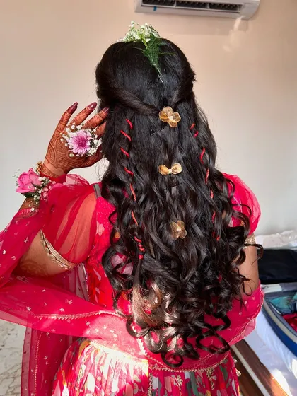 A detailed look at the beautiful Haldi hairstyle. The combination of braids, curls, and delicate accessories creates a romantic and bohemian vibe.