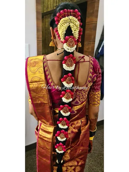 My signature Poola Jada hairstyling. This intricate floral braid is a hallmark of South Indian weddings, created here with fresh jasmine and rose-hued petals for a stunning traditional look from the back.