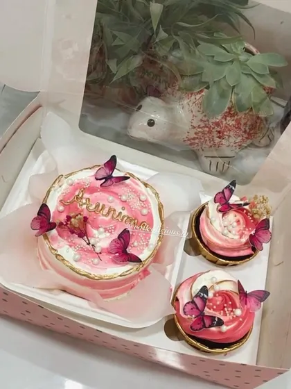 This beautiful pink bento set with two matching cupcakes is decorated with delicate butterflies and pearl sprinkles. It’s a perfect, simple gift for someone special, personalized with a name on the mini cake.