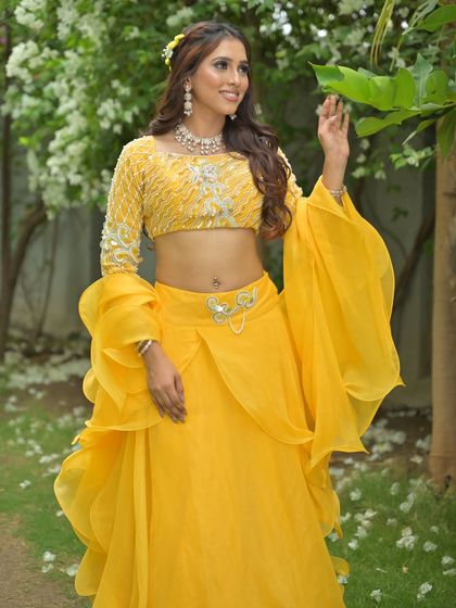 A full-length view of the yellow lehenga, capturing the flowing fabric of the skirt and sleeves. A perfect choice for a dance performance at a Sangeet.