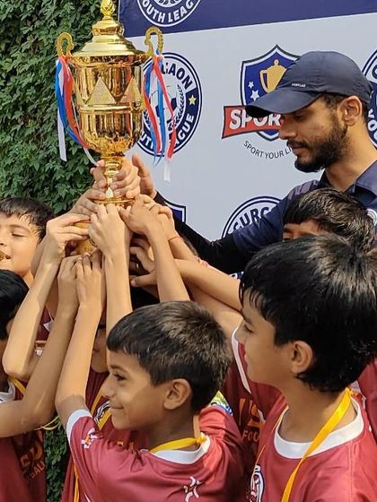 A coach and his winning team celebrating a Gurgaon Youth League victory. We guide our players at every step, sharing in their hard work and their moments of glory.