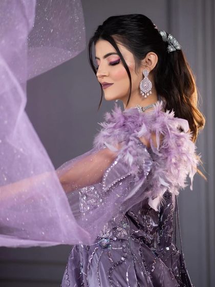A side profile shot showing the flow of the lavender gown's veil and the beautifully blended purple eyeshadow.