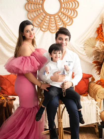 A happy family portrait. The family's joy is the centerpiece of this shot, perfectly framed by our warm and inviting autumn boho setup.