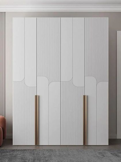 A stunning example of a modern wardrobe with curved and fluted details. The long, metallic handles add a touch of glamour to the clean white finish.