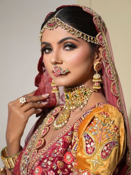 This portrait captures the royal essence of the bridal look, with the intricate nath and jhumkas adding to the traditional yet fierce vibe.
