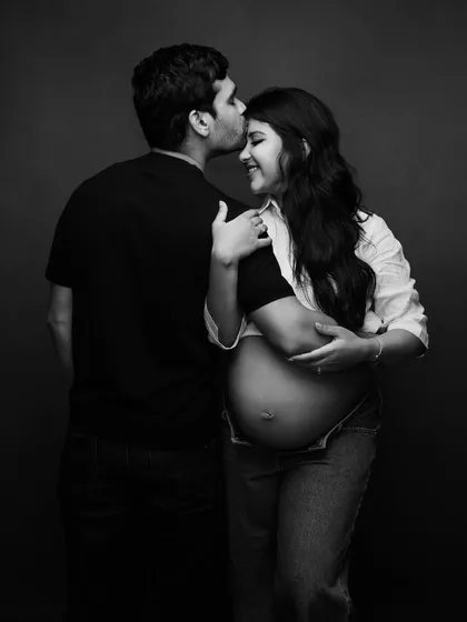 A tender and casual black and white maternity portrait. The kiss on the forehead is a simple, beautiful expression of love and care.