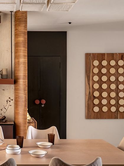 The finished wall installation in a client's dining room. The grid of stoneware discs in varying shades creates a subtle, textured focal point that complements the modern interior.
